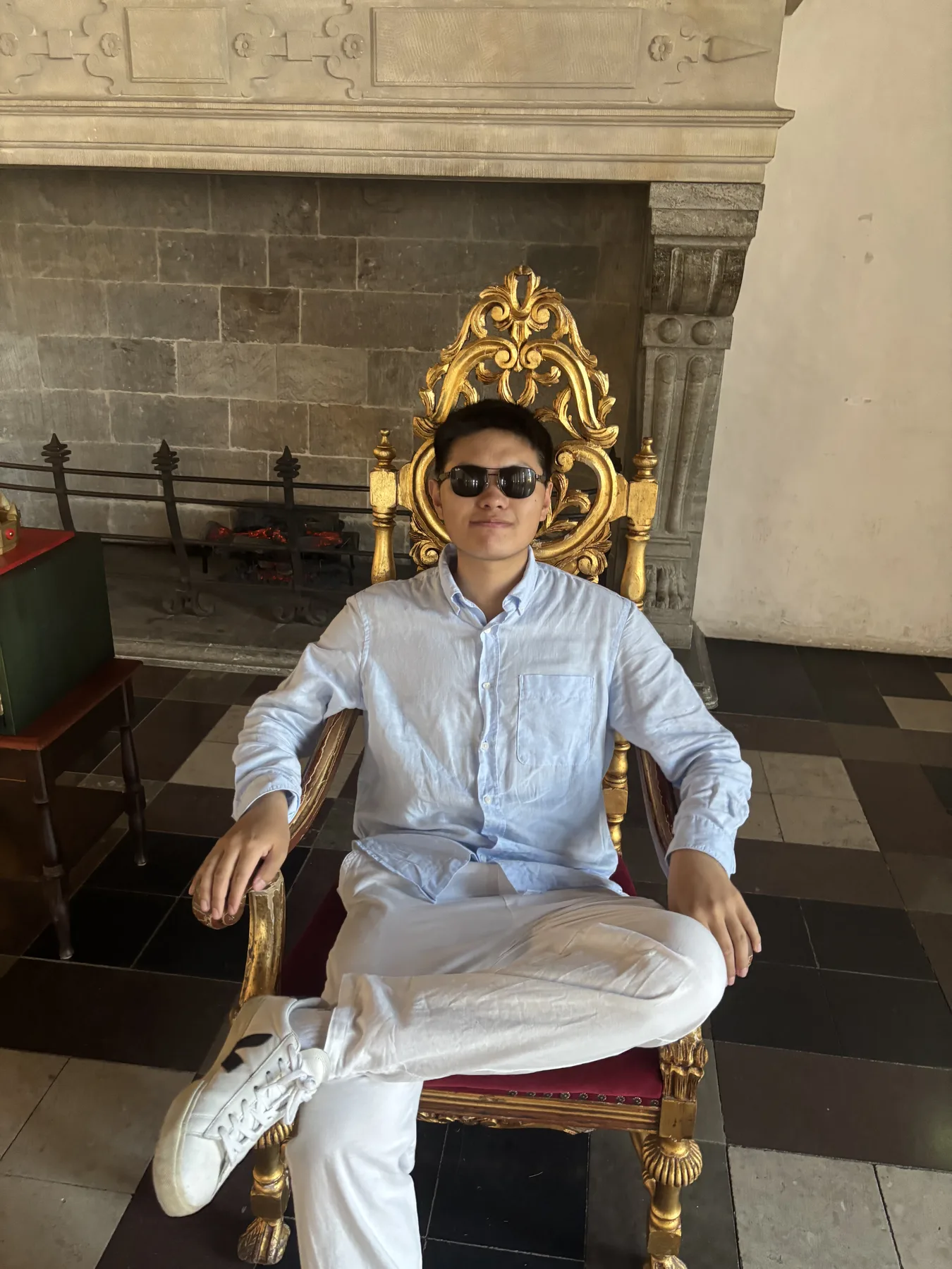 Sitting on an ornate chair indoors